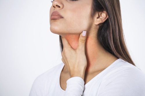 Young beautiful woman suffering from pain in throat, touching inflamed zone on her neck, cropped, empty space, sore throat